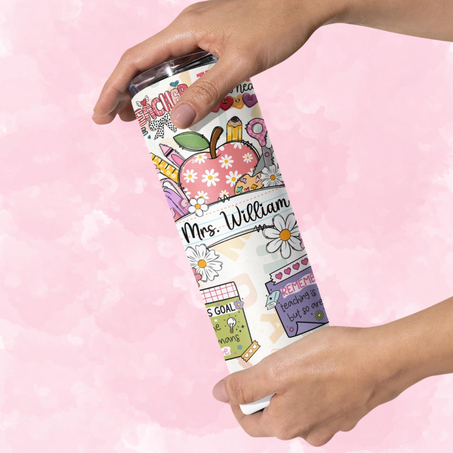 A hand holding a personalized teacher tumbler