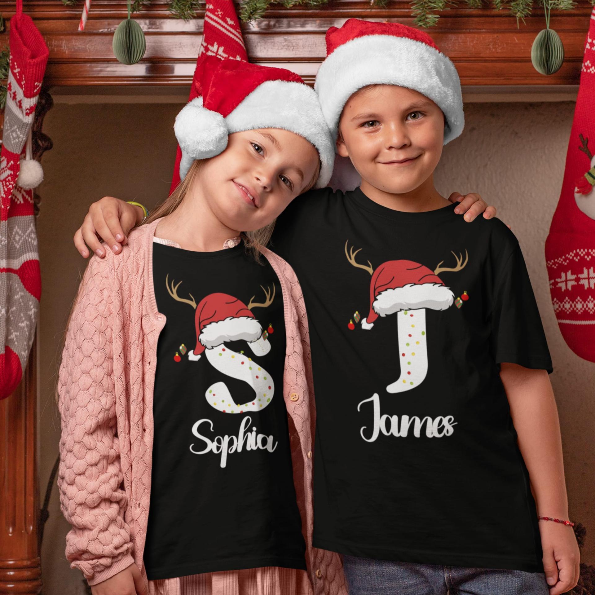Two kids in matching personalized initial Christmas shirts